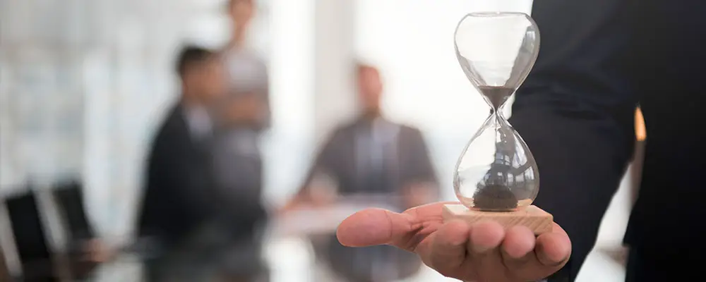 SEO-Manager und seine Aufgaben 1 SEO-Manager halten eine Sanduhr auf der flachen Hand