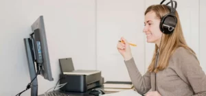 homeoffice lernen video frau kopfhoerer header — "Awareness" für Cyber-Security: Warum Schulungen auch fürs Homeoffice wichtig sind