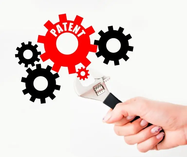 Patentrecht, Hand hält Zange, die an Zahnrad mit der Aufschrift Patent dreht
