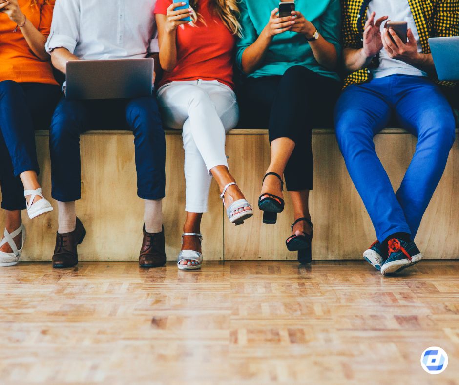 Mehrere Menschen sitzen auf einer Bank nebeneinander, nutzen Smartphones, Zielgruppenverteilung Social Media