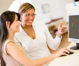 Helpful Content Google Symbol auf Computerbildschirm zwei Frauen im Büro